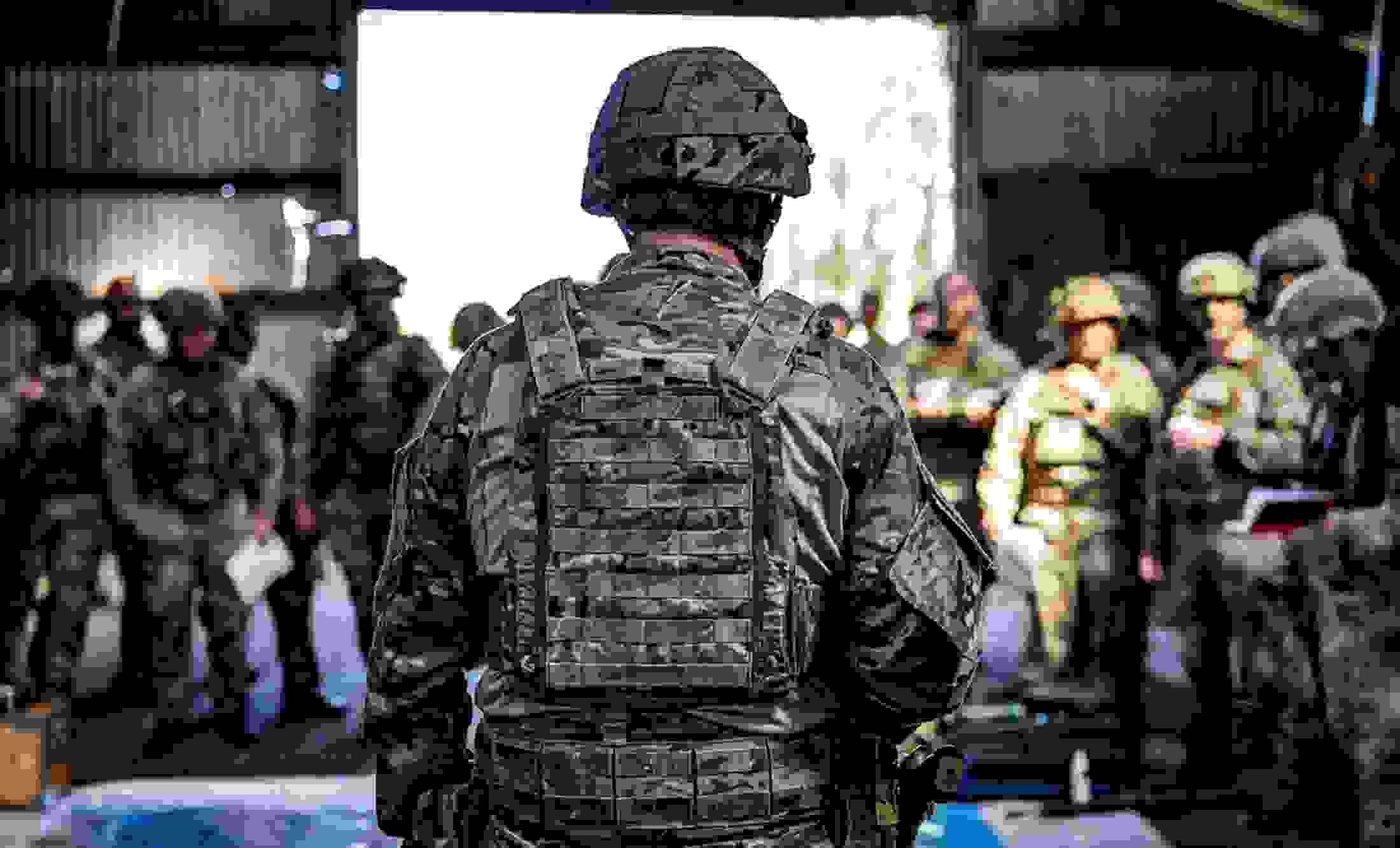 Soldat med ryggen til kameraet taler til andre soldater