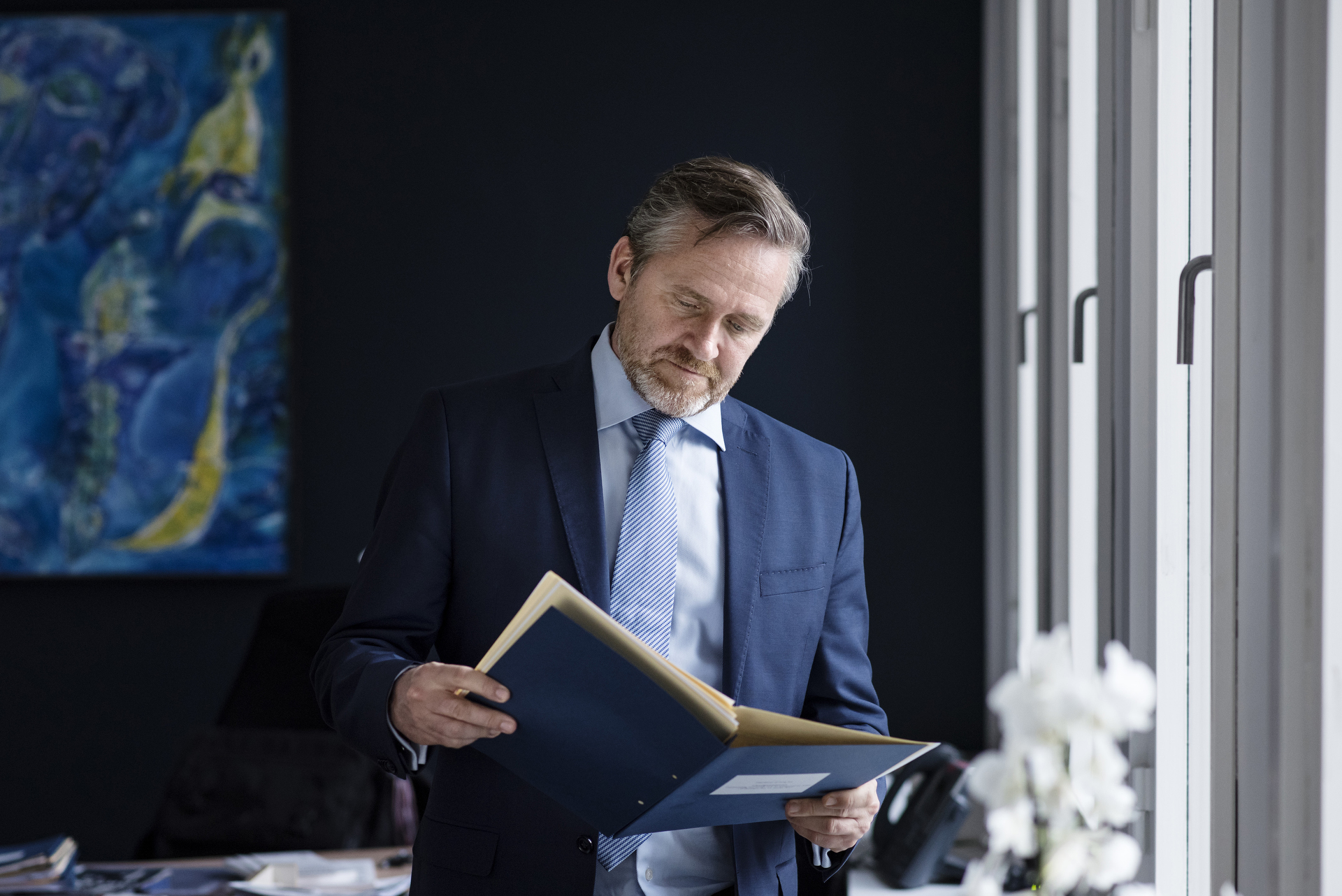 Billede af Anders Samuelsen, der læser i blå mappe