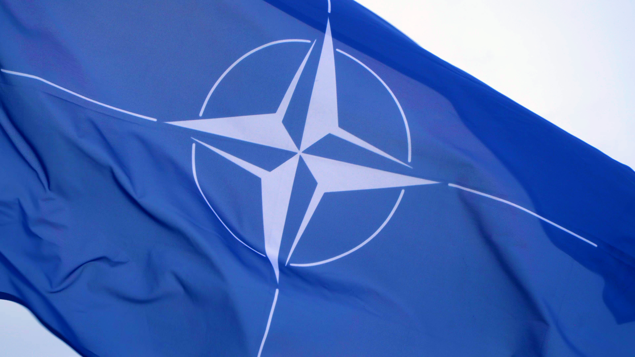 Et blåt flag med NATO logo
