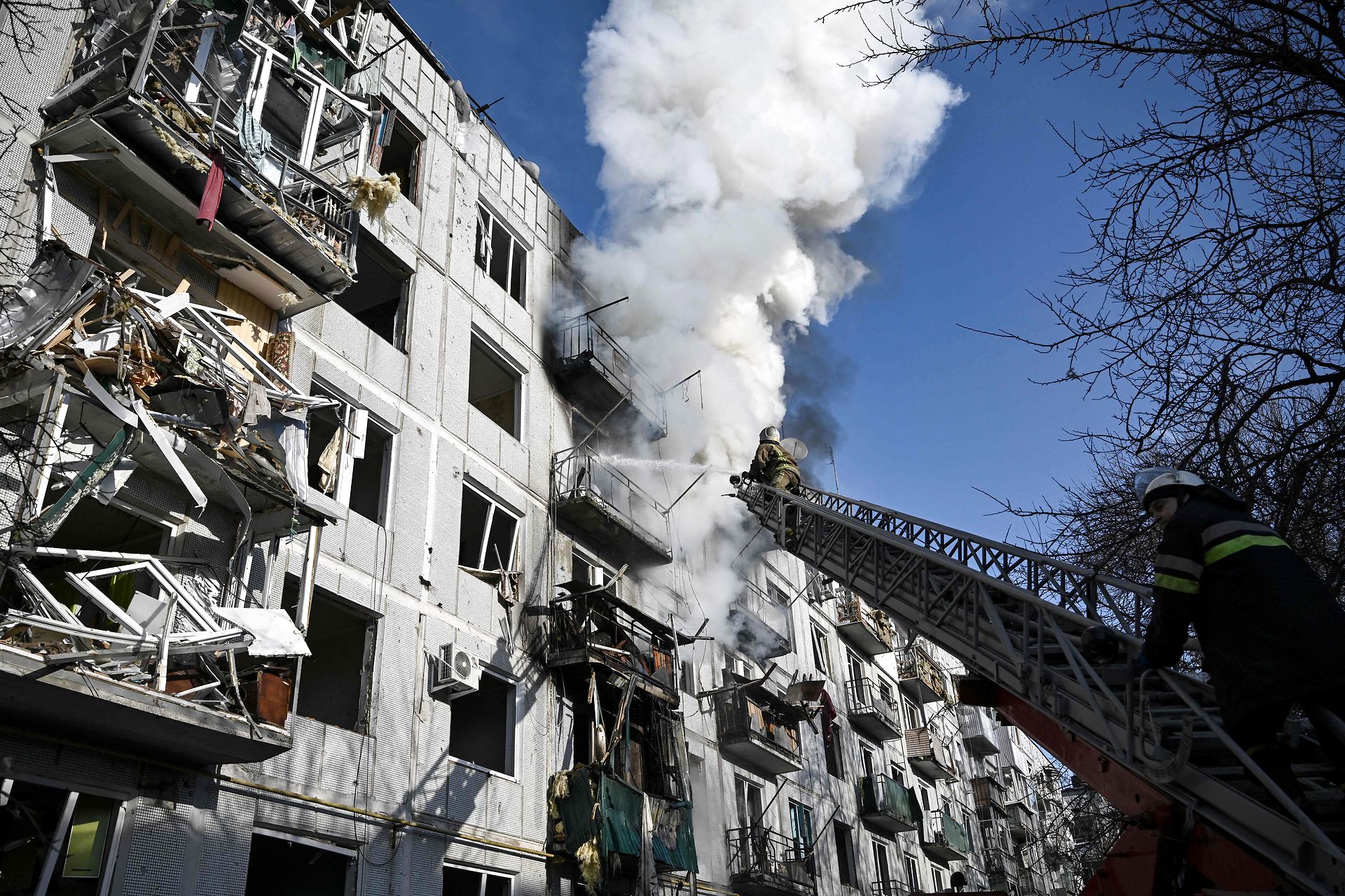 Brandfolk arbejder på at slukke brand efter bombning af by i det østlige Ukraine den 24. februar 2022.