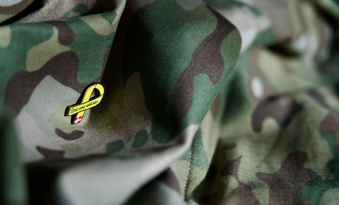 Nål med teksten "støt vores soldater" på enmilitæruniform