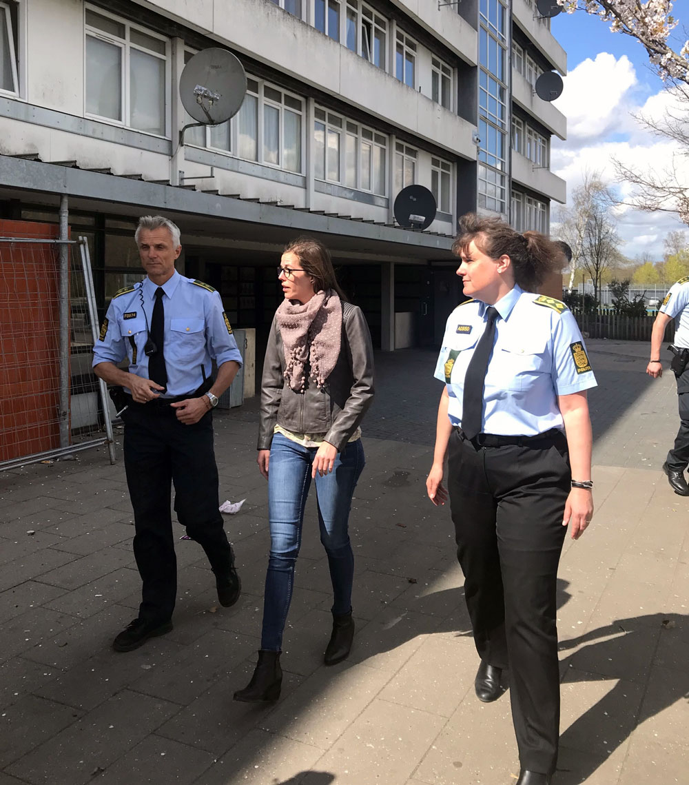 Billede af børne- og socialminister går med to politibetjente